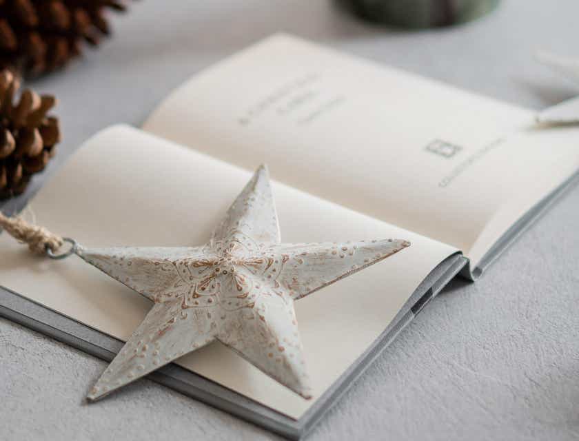 Una estrella blanca de papel sobre un libro abierto en una mesa en un logo.
