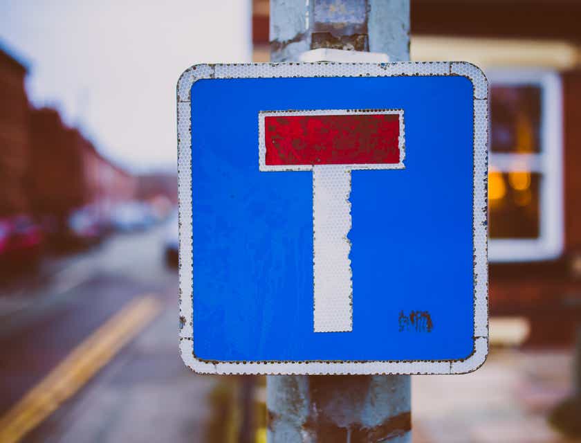 Rambu jalan berwarna biru, putih, dan merah yang menampilkan huruf T.