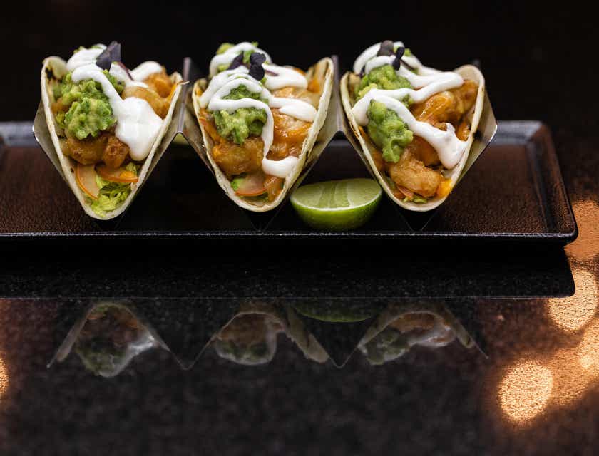 Tre tacos pronti per essere serviti in un ristorante.