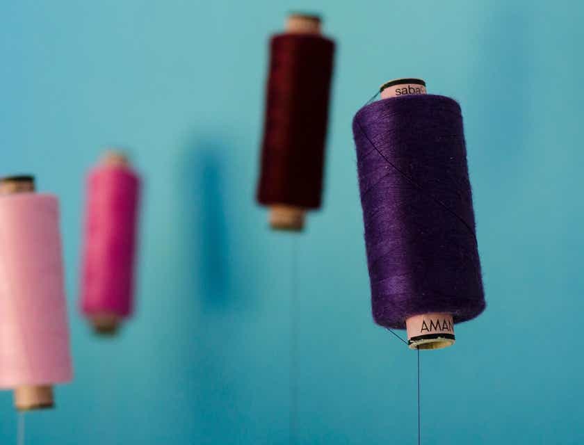 Des rouleaux de fil de différentes couleurs sur un fond bleu chez un tailleur.