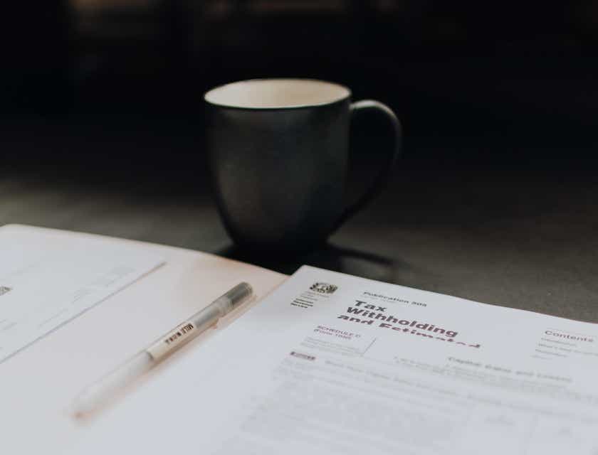 Un formulaire de déclaration d'impôts avec un stylo et un mug.