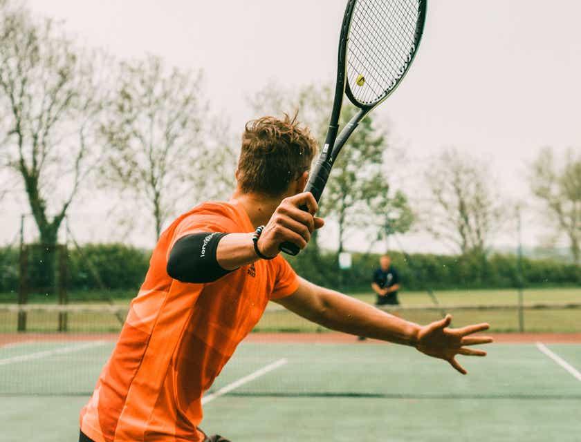 A man playing tennis with a partner.