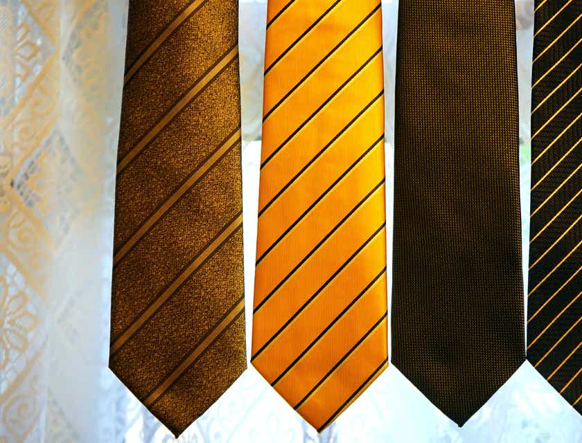 Yumuşak gri bir arka plana karşı düzgün bir şekilde dizilmiş dört çeşit kravat.