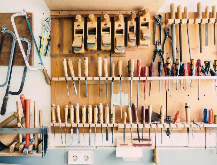 Una variedad de herramientas colocadas en un estante de pared, en un logo para negocios de herramientas.