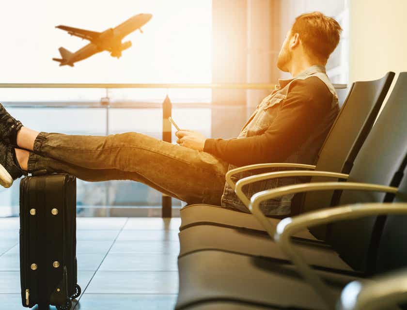 Um homem em um aeroporto esperando seu voo para viajar.