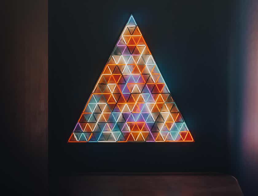 Un logo con un gran triángulo brillante que se muestra en una habitación oscura.