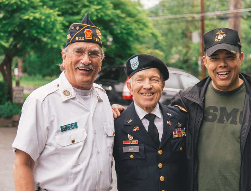Un trío de veteranos sonriendo para una fotografía.