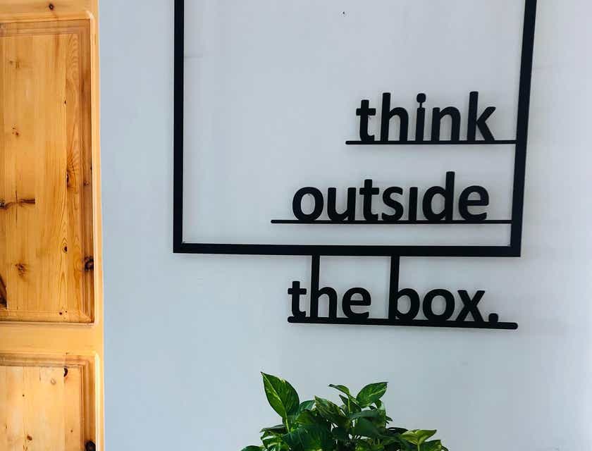 Un mensaje en la pared que dice: piensa fuera de la caja, en un logo de sabiduría.