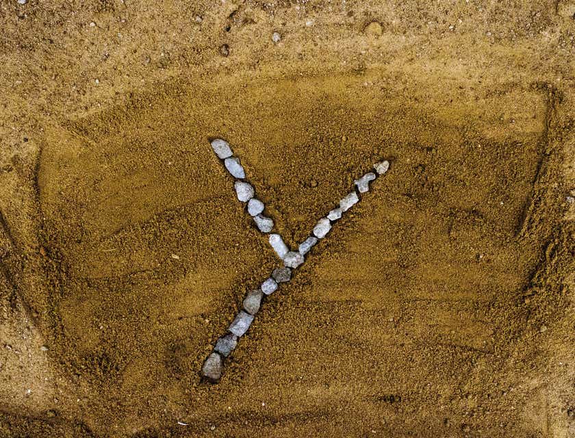 The letter "Y" laid out in pebbles on the sand.