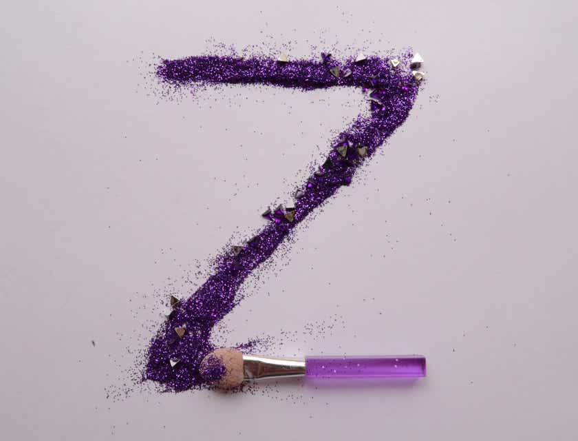 Una lettera "Z" scritta con un ombretto viola glitterato, la cui base è formata da un piccolo pennellino.